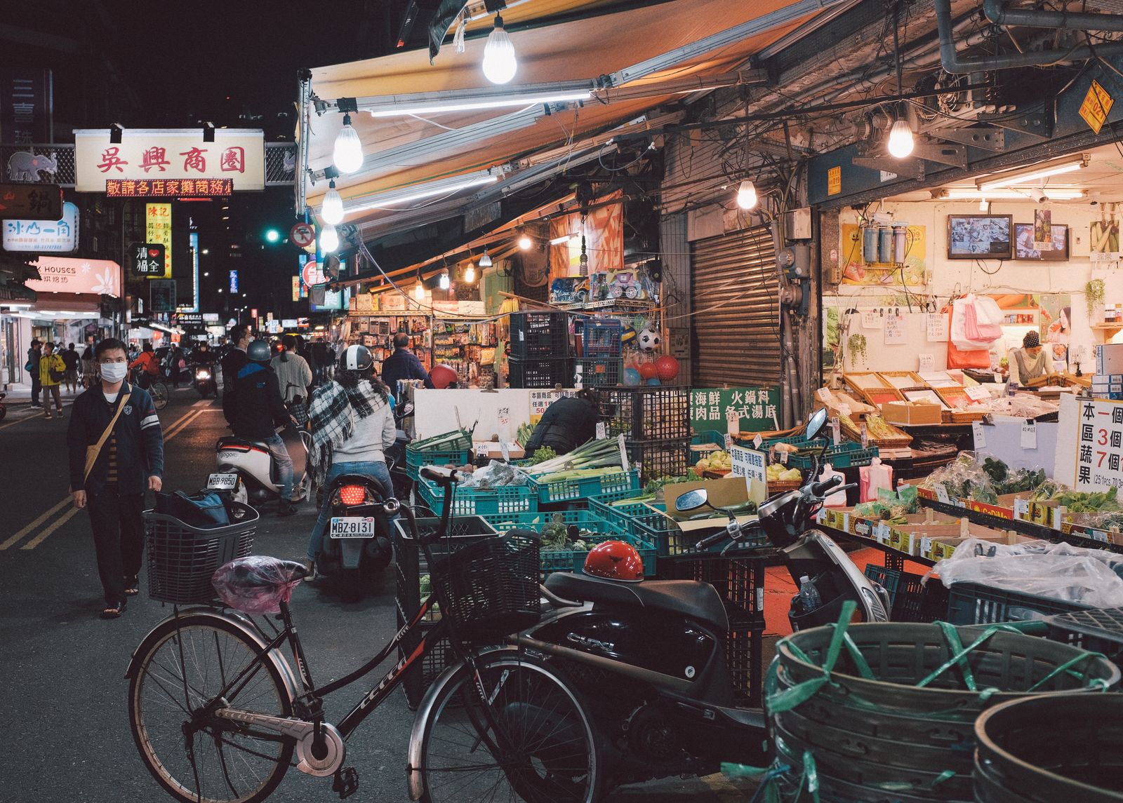 Scooters, stalls and shoppers in a Taipei night market