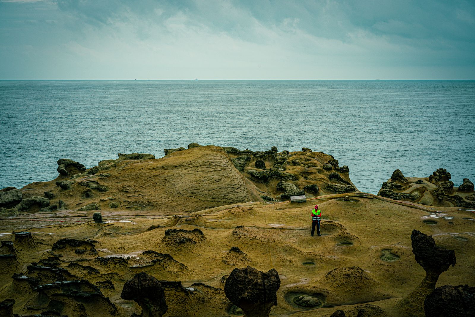 A traveller among the eroded rock shelves of Yehliu Geopark