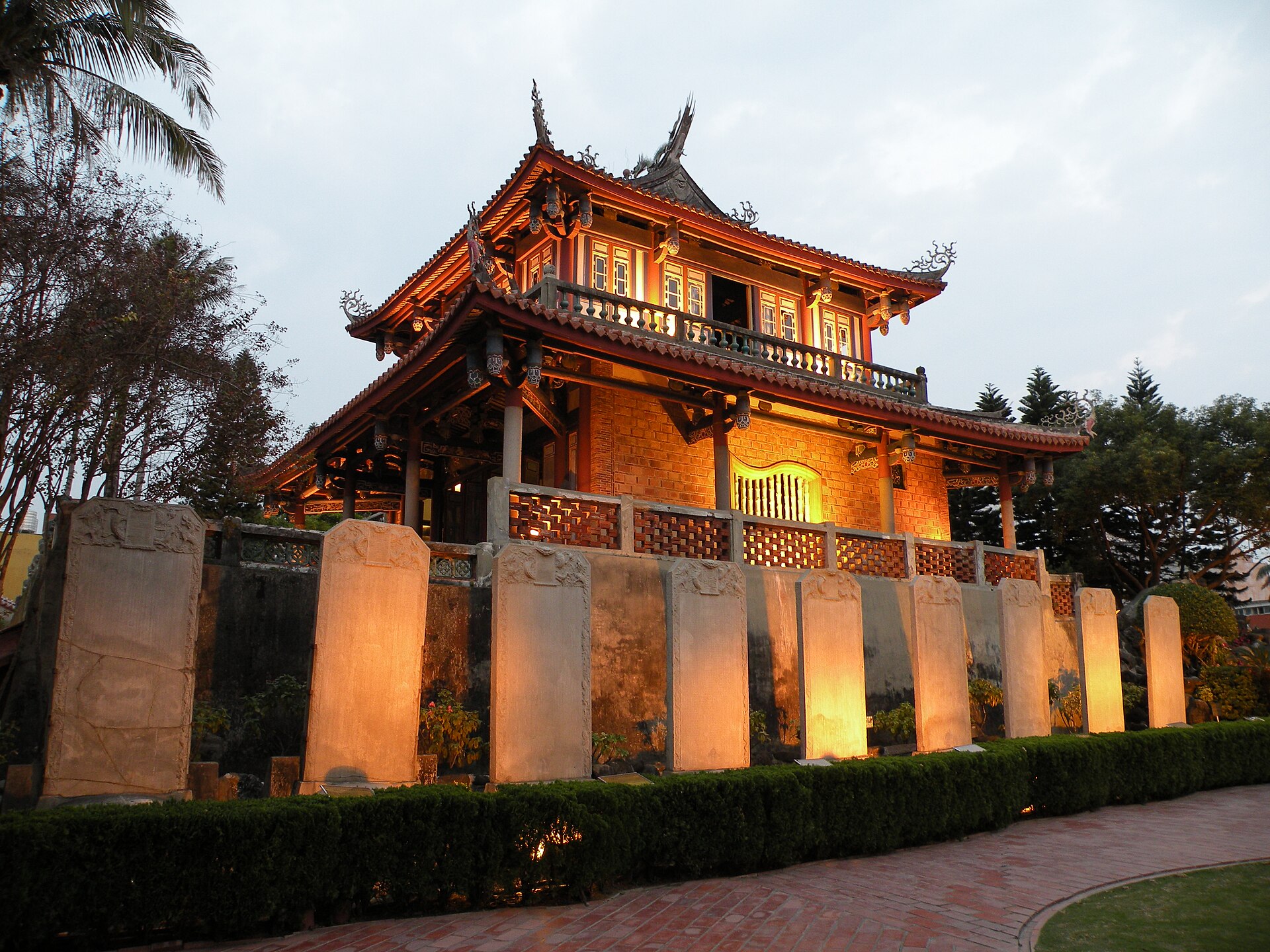 Chihkan Tower illuminated warmly behind its stone wall in Tainan at night