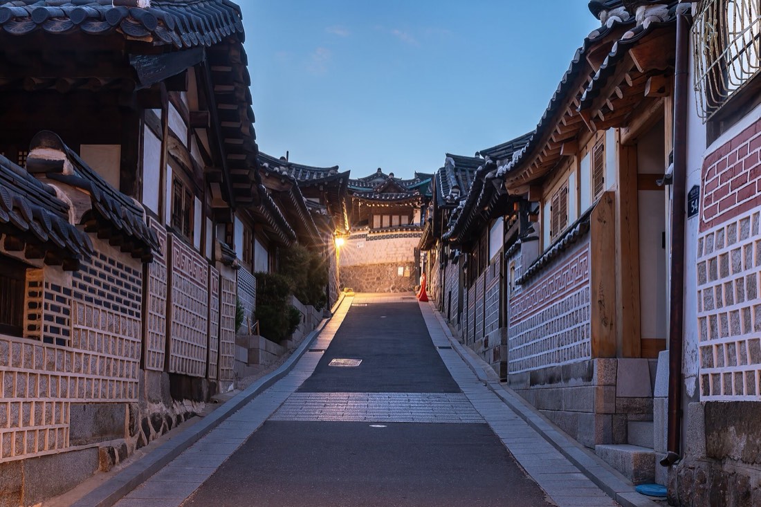 Hanok houses lining a sloping Bukchon lane at blue hour